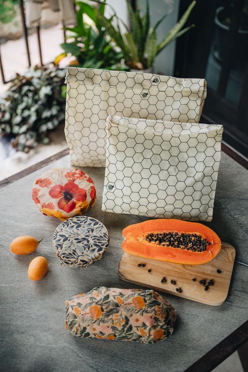 SuperBee honeycomb beeswax bags on a table with papaya, dragon fruit and kumquats