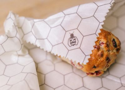 A honeycomb-print beeswax wrap folded around a muffin