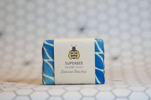The dishwashing bar in a blue beeswax wrap on white hexagon tiles