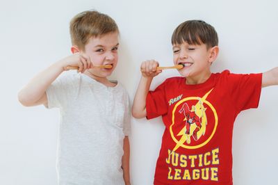Two boys brushing their teeth side by side with Dentos toothpaste tablets