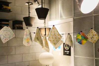 Finished DIY beeswax wraps pegged on a line to dry in a kitchen