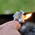 A natural beeswax fire starter catching a flame