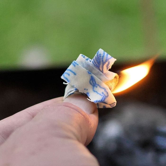 A natural beeswax fire starter catching a flame