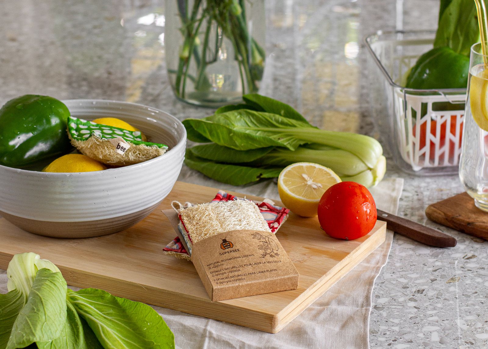 A natural luffa dish scrubber on a wooden board with fresh vegetables