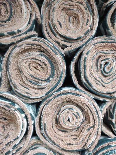 Rolled SuperBee reusable kitchen cloths stacked in a pile