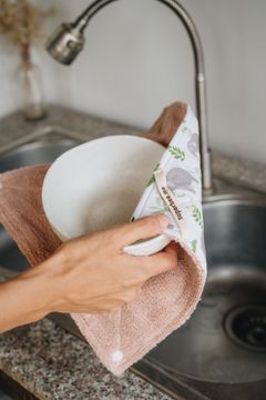 Wiping a spill from a table with a reusable SuperBee kitchen cloth
