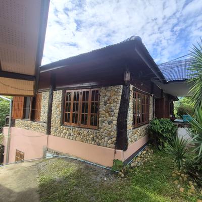 The stone-walled house at SuperBee HQ with its teak-framed windows
