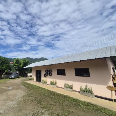The SuperBee workshop's main building, the bee logo on its wall, the courtyard and the hills of Hang Dong behind