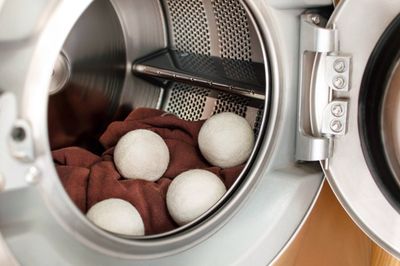 SuperBee wool dryer balls tumbling with laundry inside a dryer drum