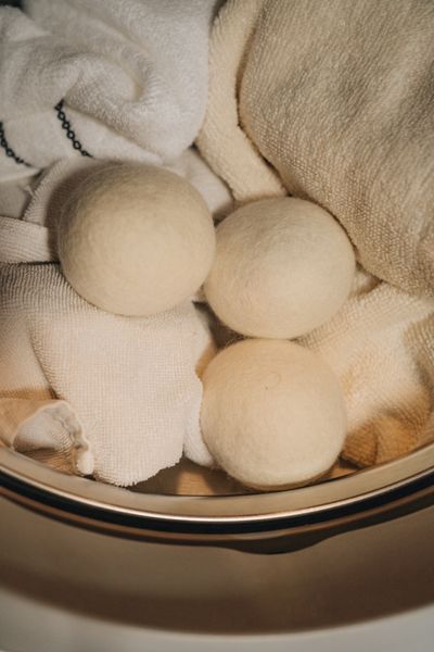 SuperBee wool dryer balls resting on folded towels in a dryer
