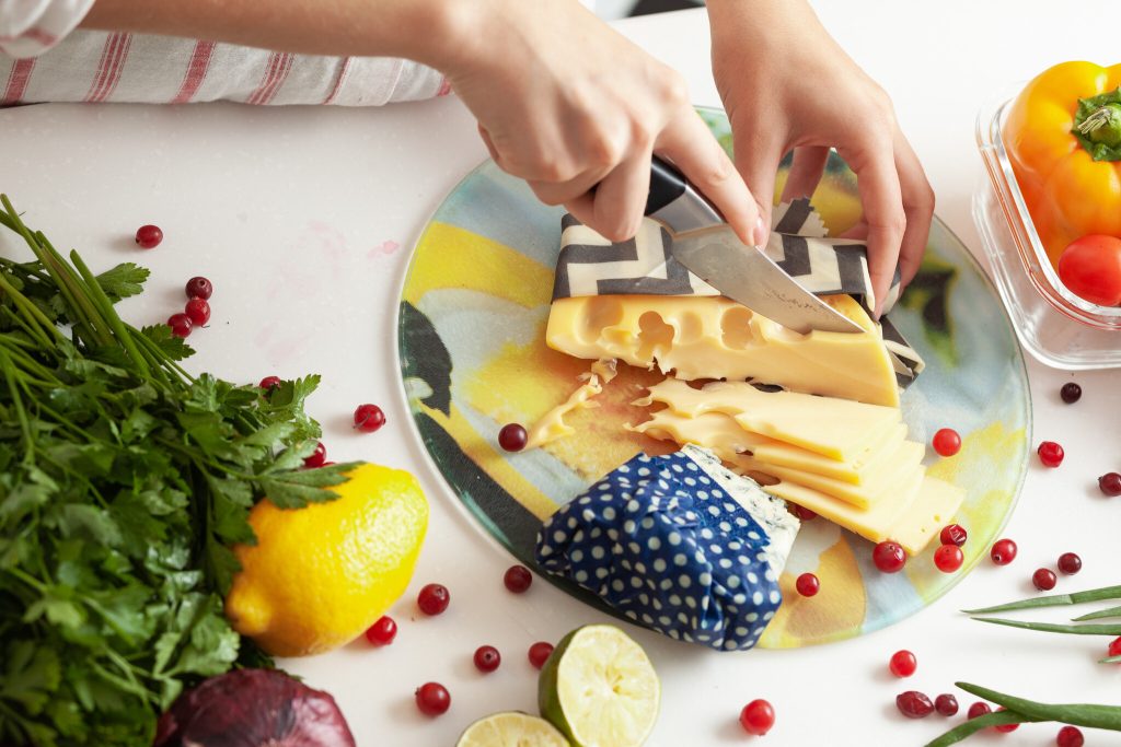 Wrapping a block of cheese in a reusable beeswax wrap instead of plastic